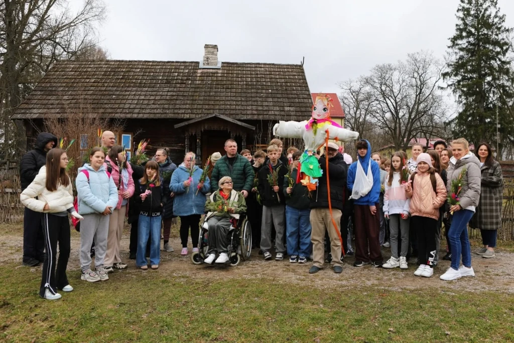 Uczestnicy powitania wiosny z Marzanną przed budynkiem skansenu