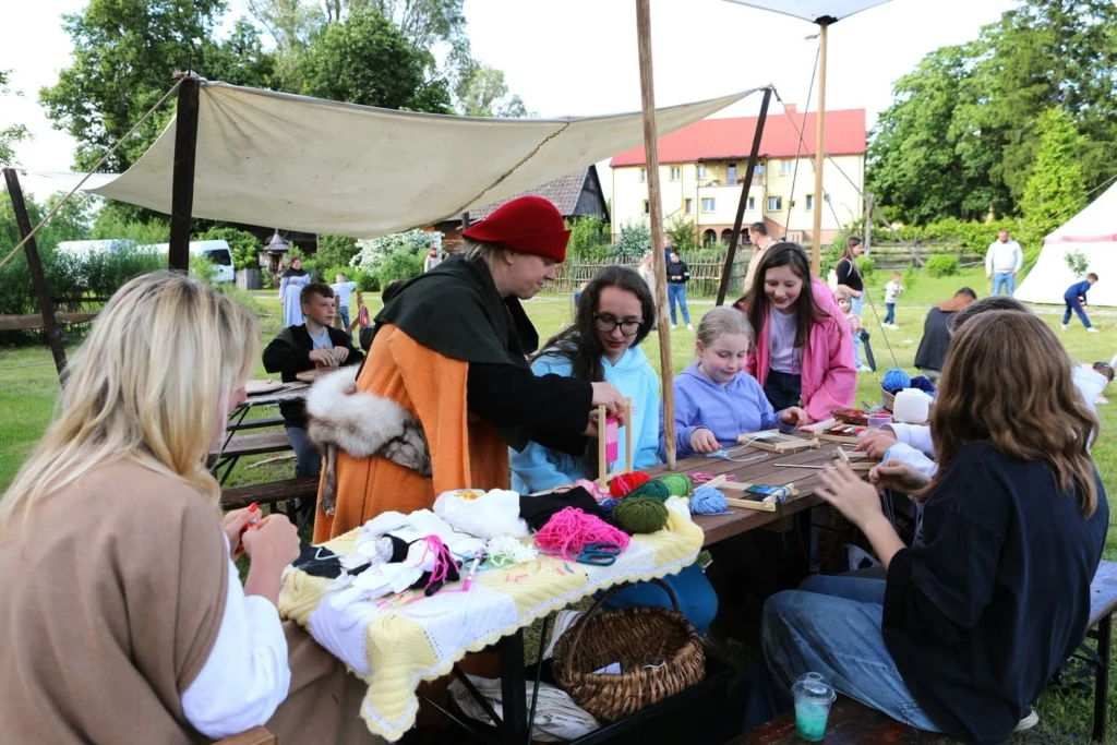 Rodziny przy stoisku warsztatowym w skansenie